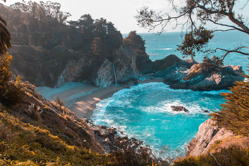 Crique turquoise au pied d'une falaise boisée